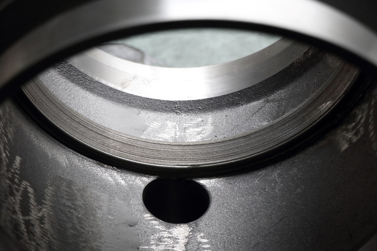 Close-up of laser cladding process repairing worn areas of double eccentric valve sealing surface