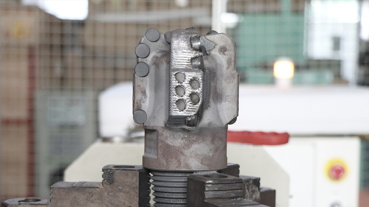 レーザークラッディング処理後のPDCドリルビット上のタングステンカーバイド耐摩耗層のクローズアップ詳細画像。